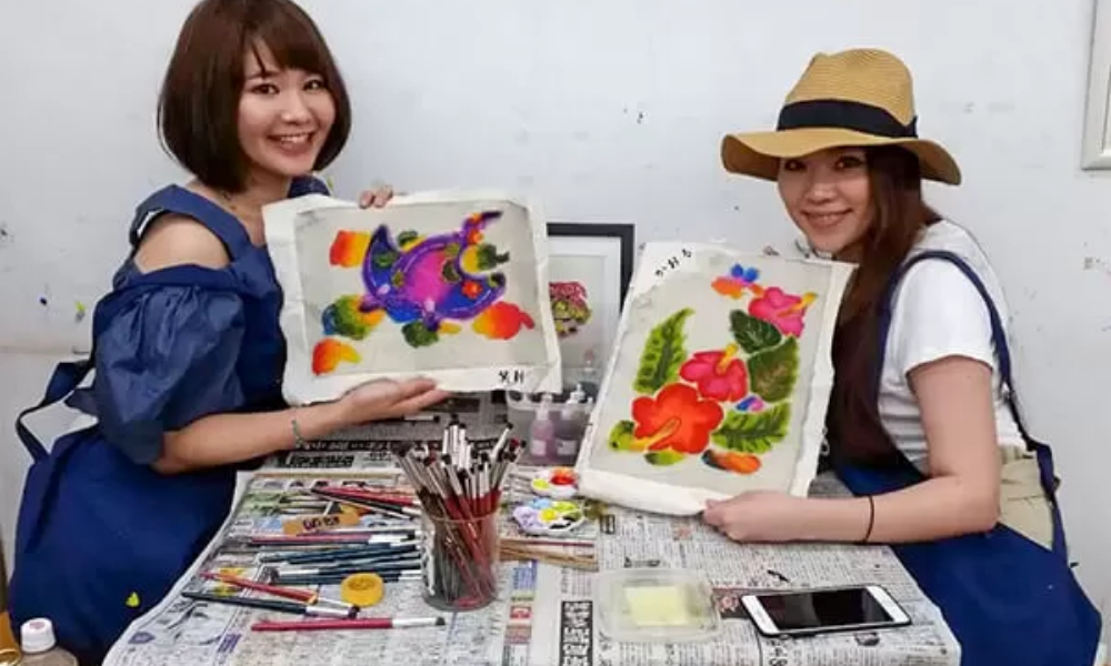 沖縄の紅型染め体験で鮮やかな顔料を塗る様子