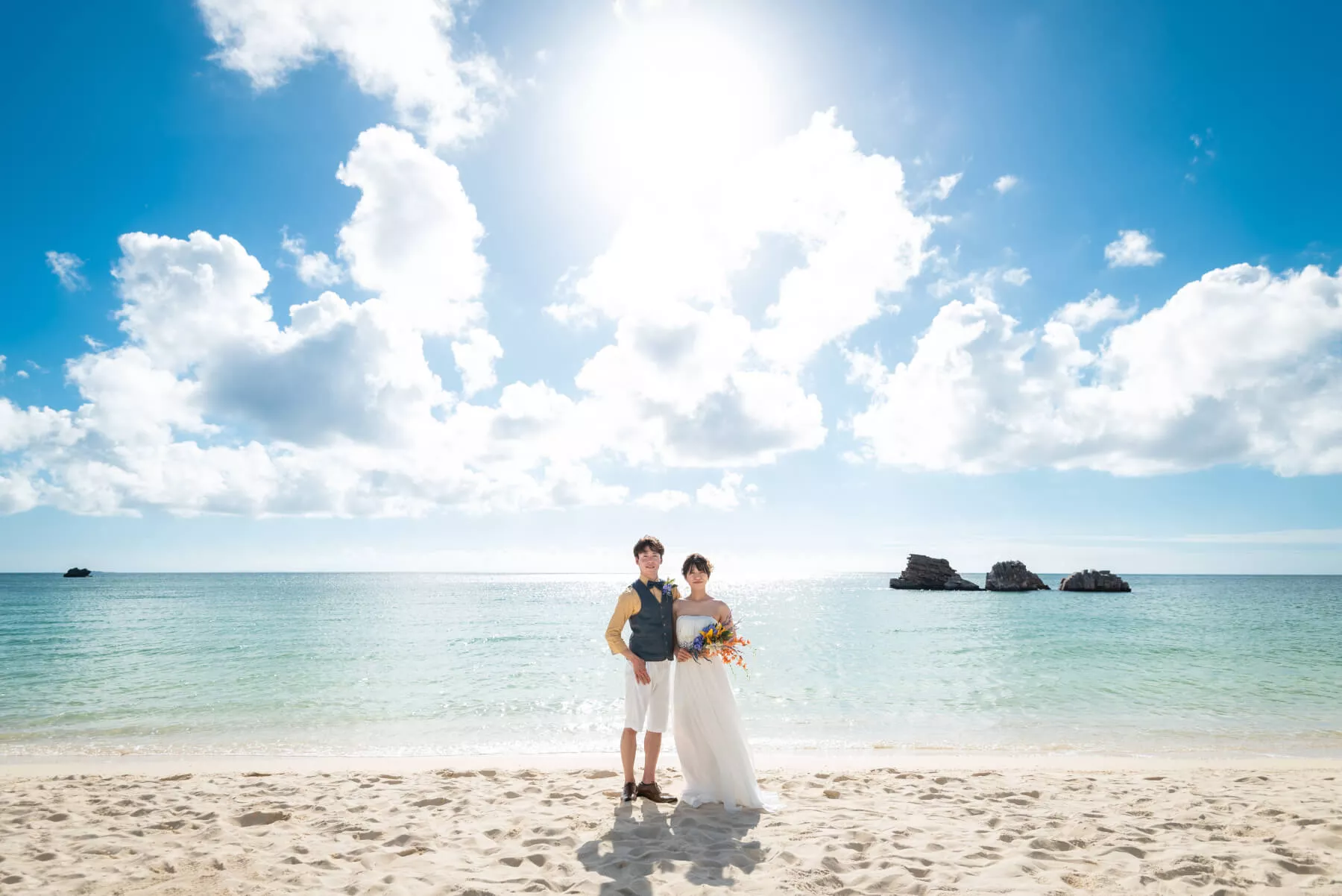 沖縄ウェディングフォト やんばるの青い海と白浜ビーチで佇む新郎新婦
