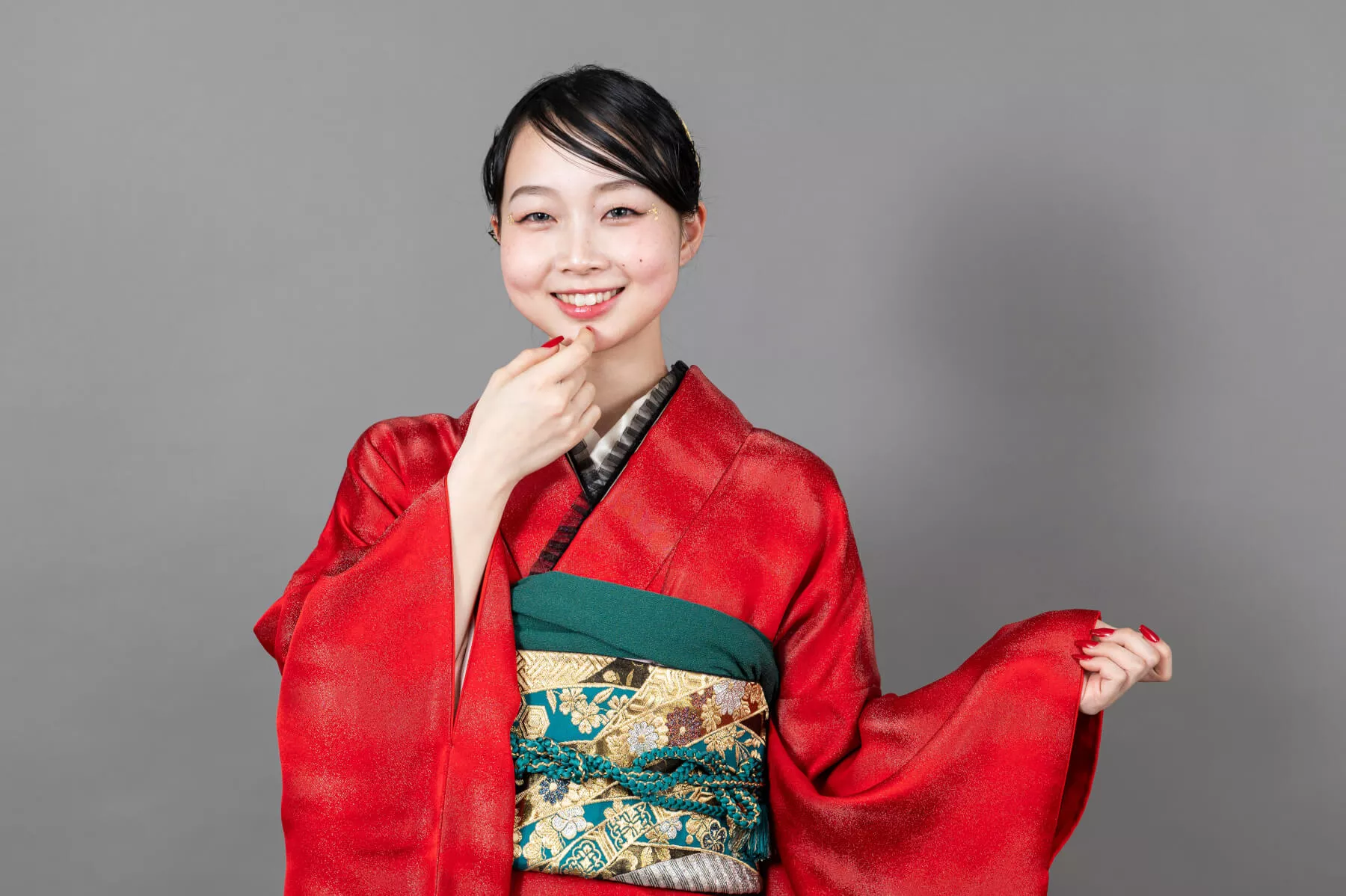 沖縄成人式振袖写真 あごに手を添えて上品に微笑む赤い振袖姿の女性ポートレート