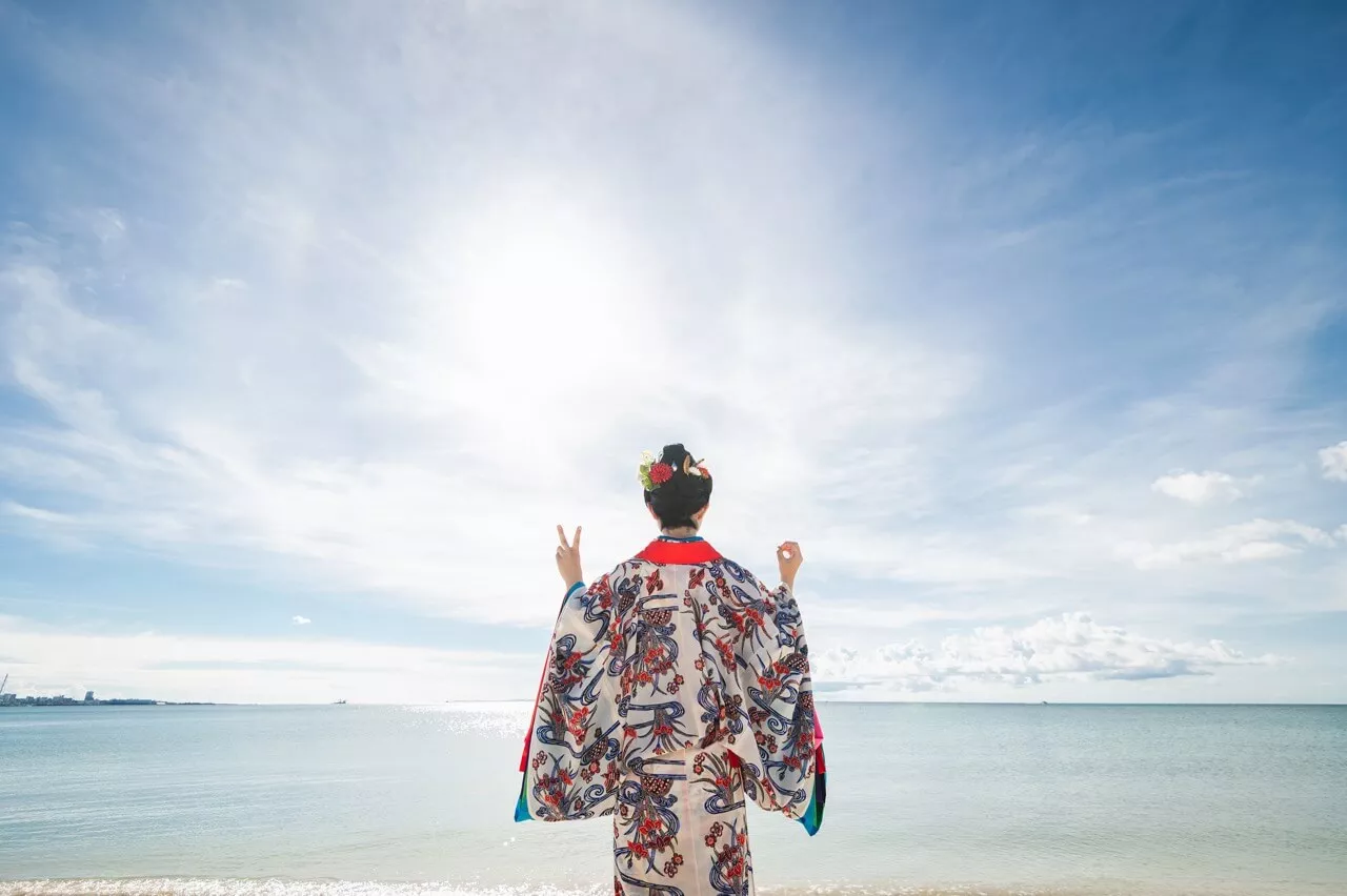 沖縄成人式撮影 伝統衣装の紅型琉装を着て海を背景に佇む女性の立ち姿