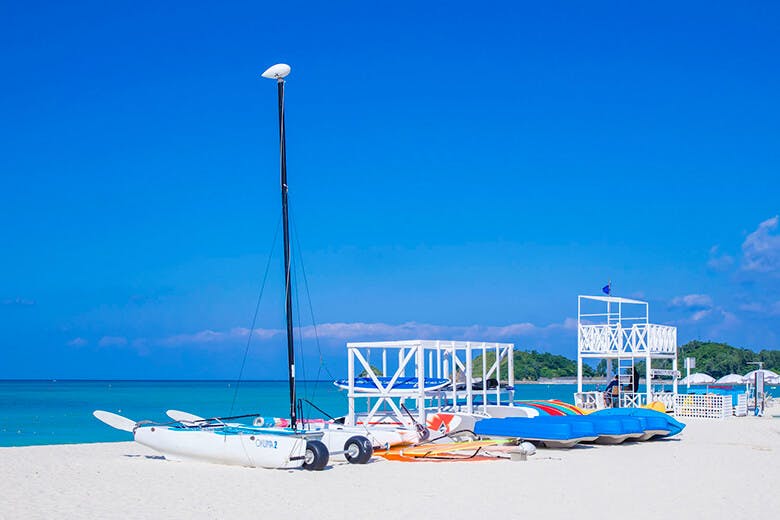 オクマビーチ|白いビーチに並べられた、ヨットやカヤックなど。