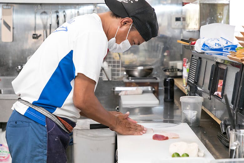 国頭港食堂（くにがみみなとしょくどう）｜さくから刺身を切り出す男性