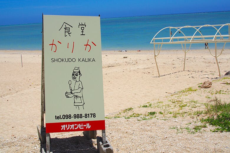 食堂かりか|ビーチに置かれた食堂の看板
