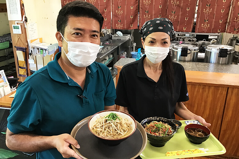 道の駅ゆいゆい国頭｜国頭特産の豚肉「くんじゃん豚」を使った料理を持つスタッフさん達