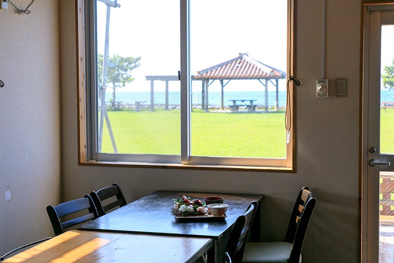 国頭港食堂（くにがみみなとしょくどう）｜窓の外には海と赤瓦の東屋が見える景色