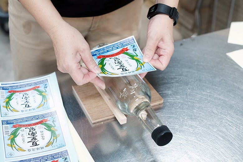 神谷酒造所|手作業で瓶にラベルを貼る様子