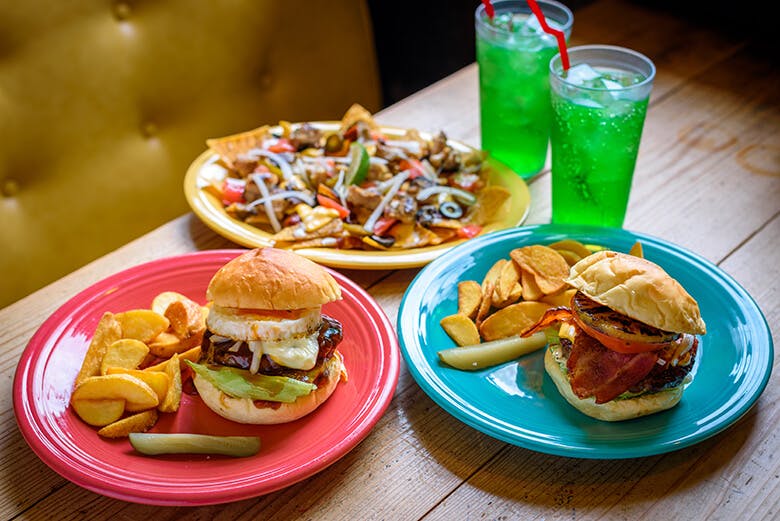 GORDIES(ゴーディーズ)|カラフルなプレートに乗った、バーガー各種とメロンソーダ