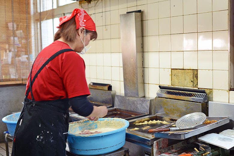 くになか食堂｜てんぷらを見事な手さばきで次から次へと揚げていく女性スタッフ