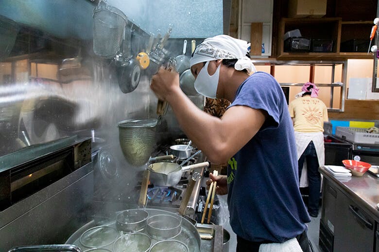 金月(きんちち)そば|厨房で麺を湯切りする様子