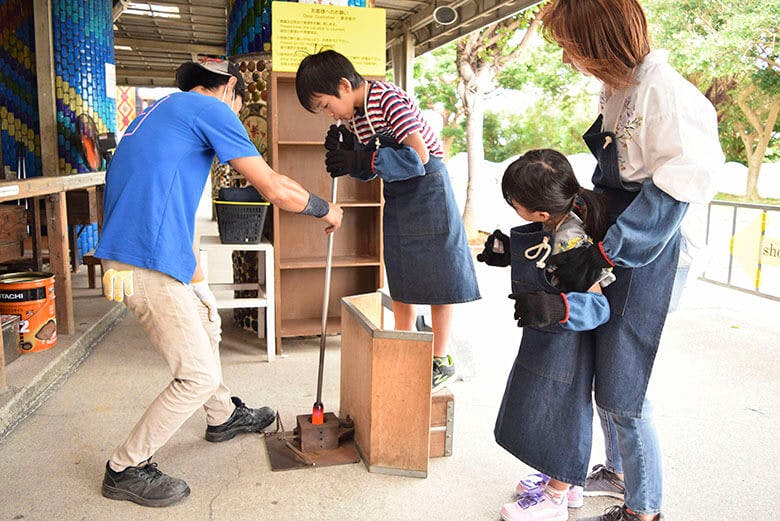 琉球ガラス村｜ガラス吹き体験をする小学生ぐらいの男の子と家族