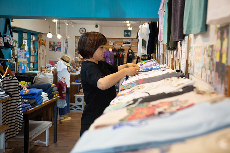 琉球ぴらす｜商品を整える店長の翁長（おなが）さん