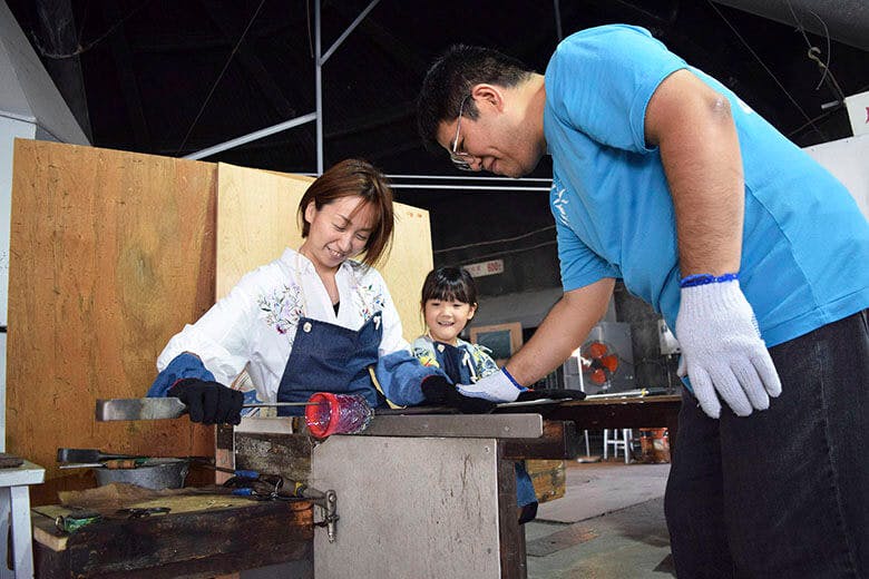 琉球ガラス村｜ガラス体験をする女性と、笑顔で見つめる娘さん