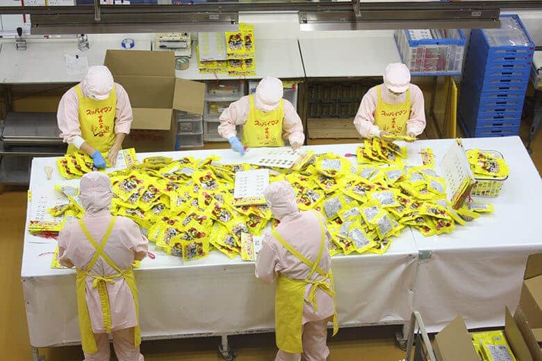 上間商店｜工場内で選別包装する人々（2）