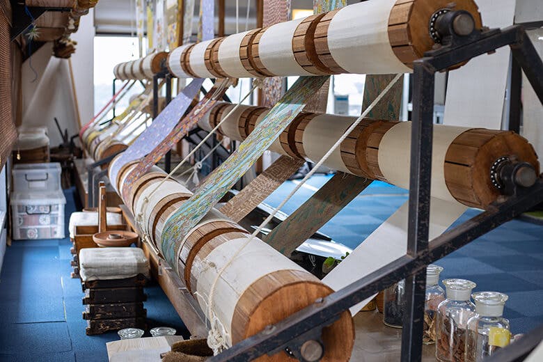 首里琉染|大きな作業台に張られ、色とりどりの絵柄を施された布たち