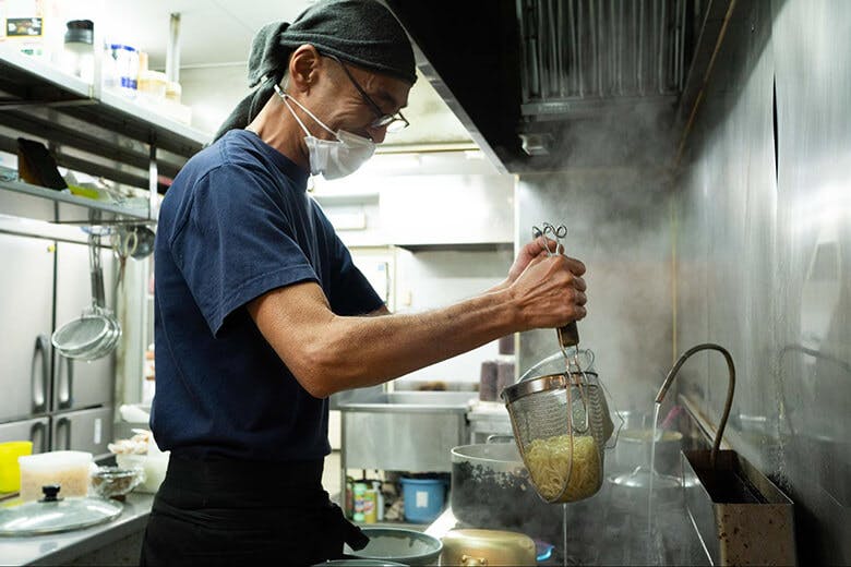 古謝そば屋｜麺の湯切りをする男性