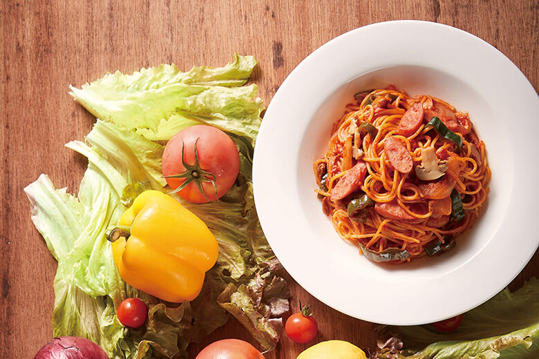 エーデルワイス沖縄｜パプリカやトマトとディスプレイされた、白い丸皿に盛られたナポリタン。