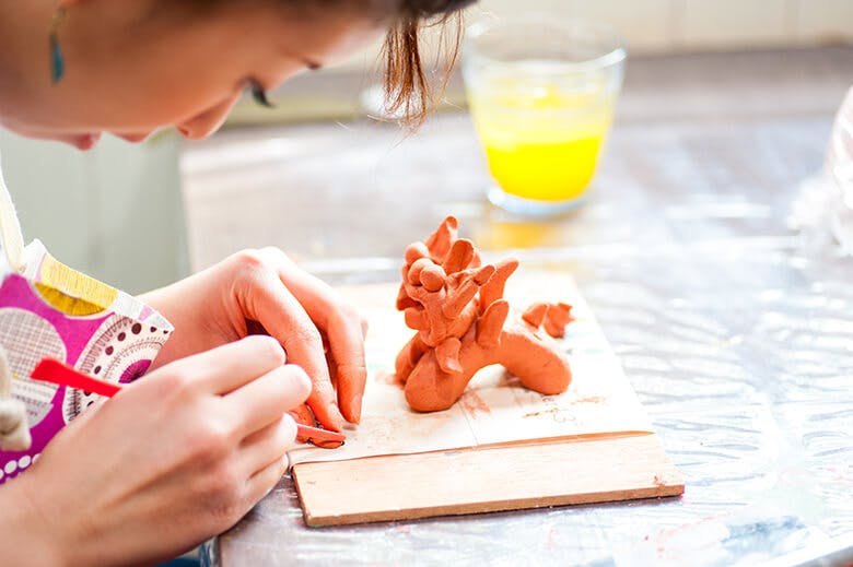 Atelier43(アトリエヨンサン)|シーサー作りを体験している女性