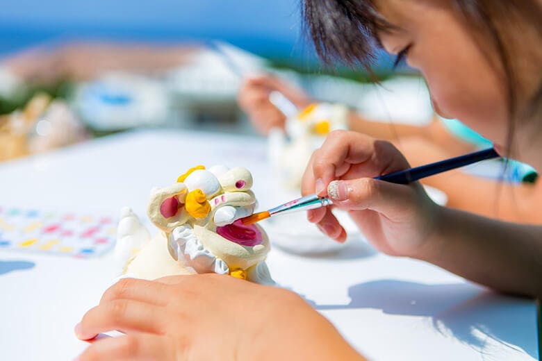 太陽が窯(てぃだががま)|シーサーの絵付け体験をする女の子