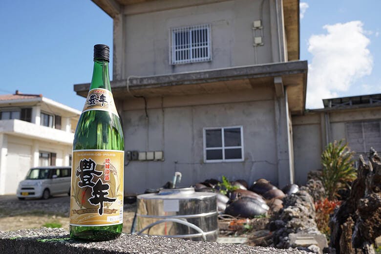 渡久山酒造|塀の上に置かれた「豊年」の一升瓶