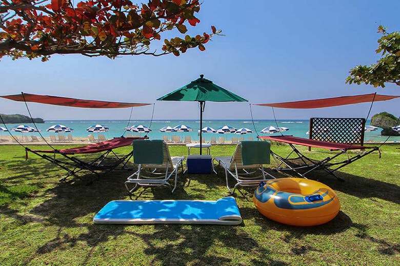 ニライビーチ｜芝生スペースに設置されたパラソルとチェアのレンタルセット