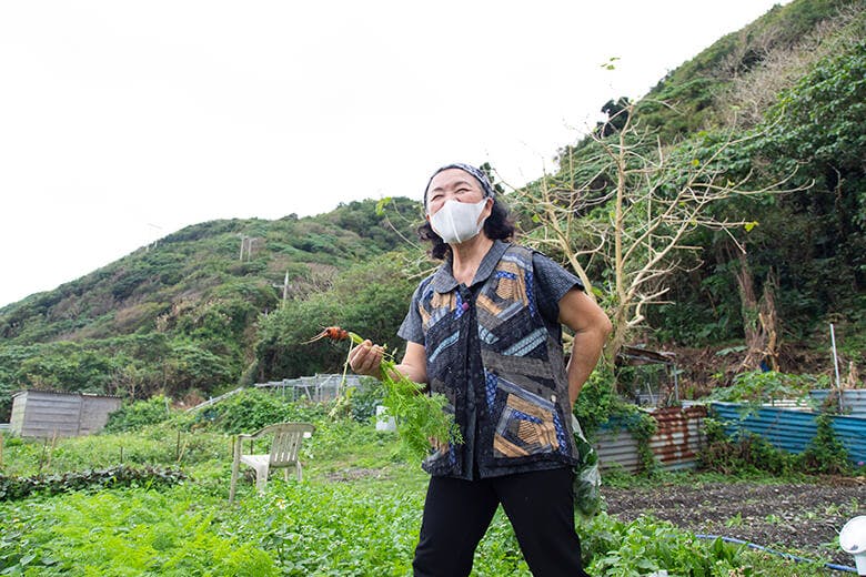 笑味（えみ）の店｜人参を持つ店主の金城恵美子さん