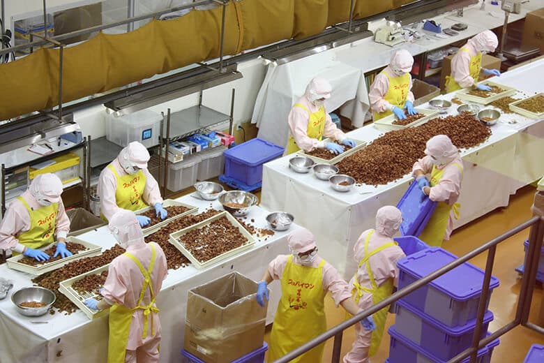上間商店｜工場内で選別包装する人々（1）