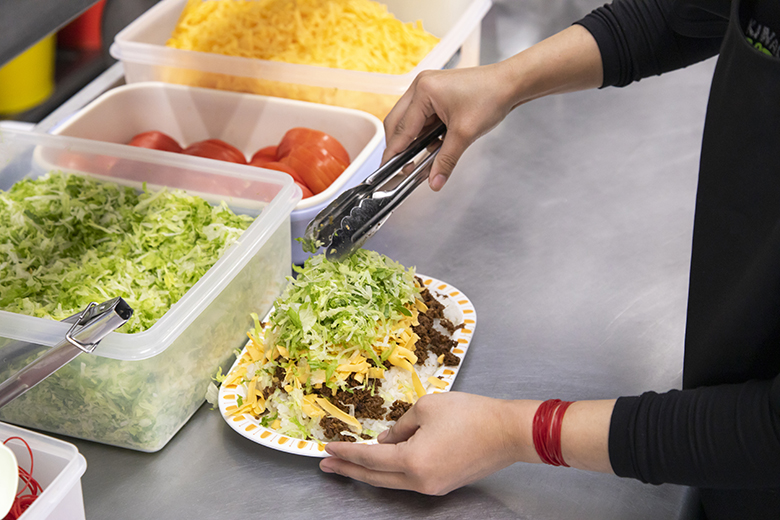 キングタコス 金武(きん)本店|タコライスを盛り付けている様子