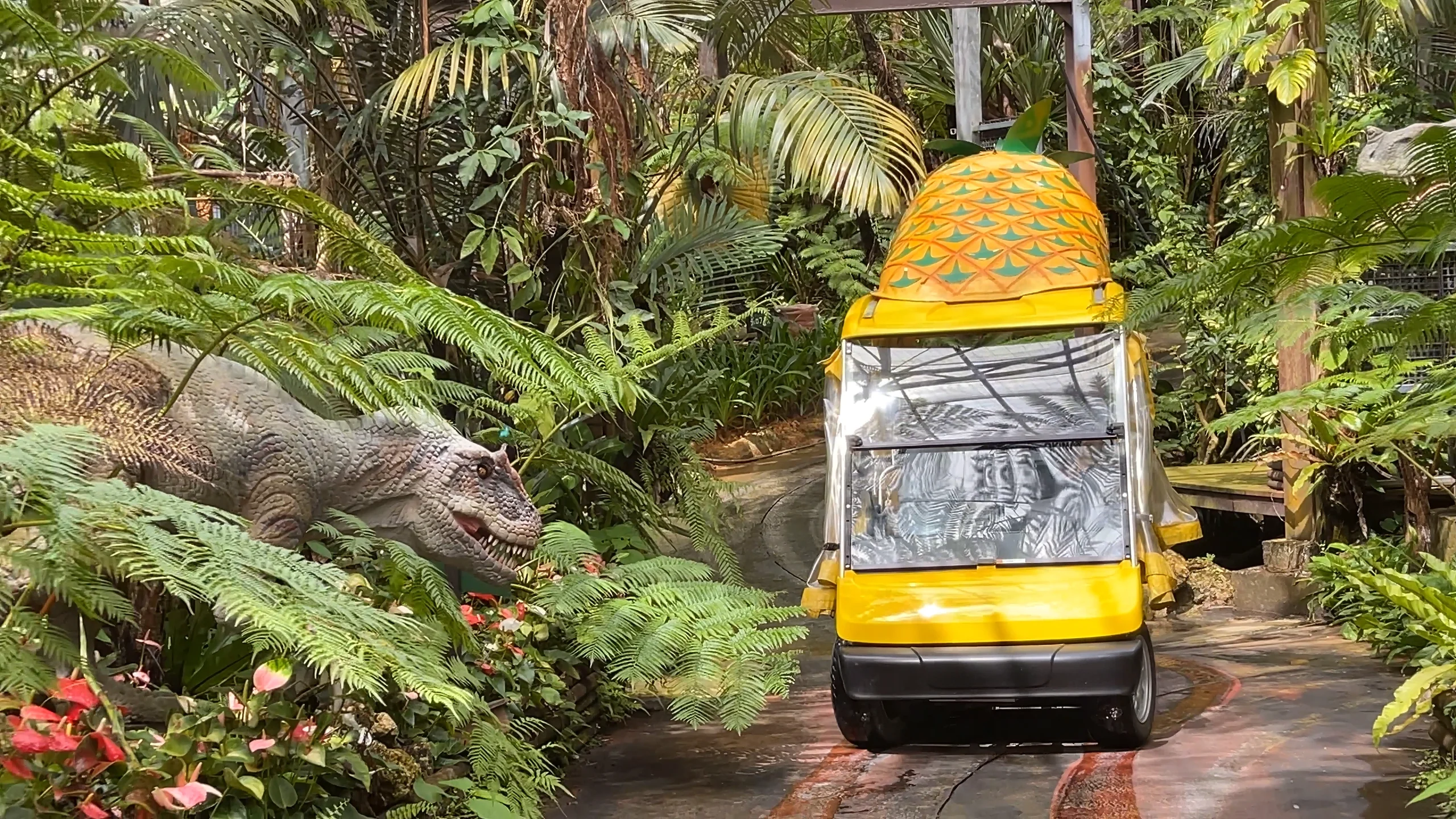 黄色いパイナップル号が亜熱帯の植物が茂る園内を進む様子。自動運転で楽々観光