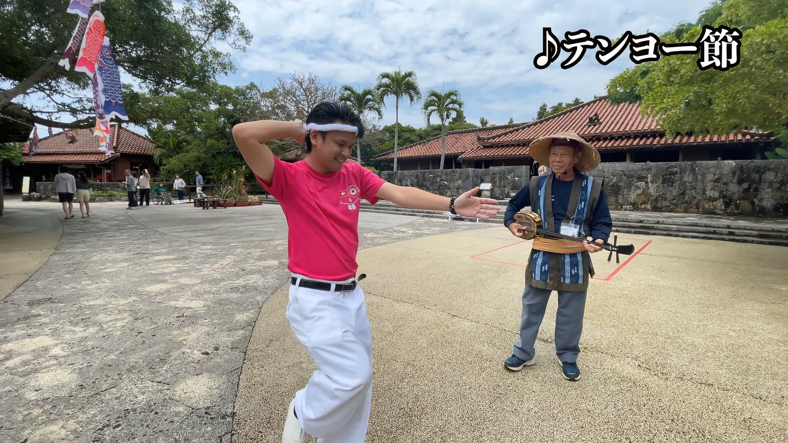 赤瓦の古民家が立ち並ぶ琉球王国城下町で体験を楽しむ様子