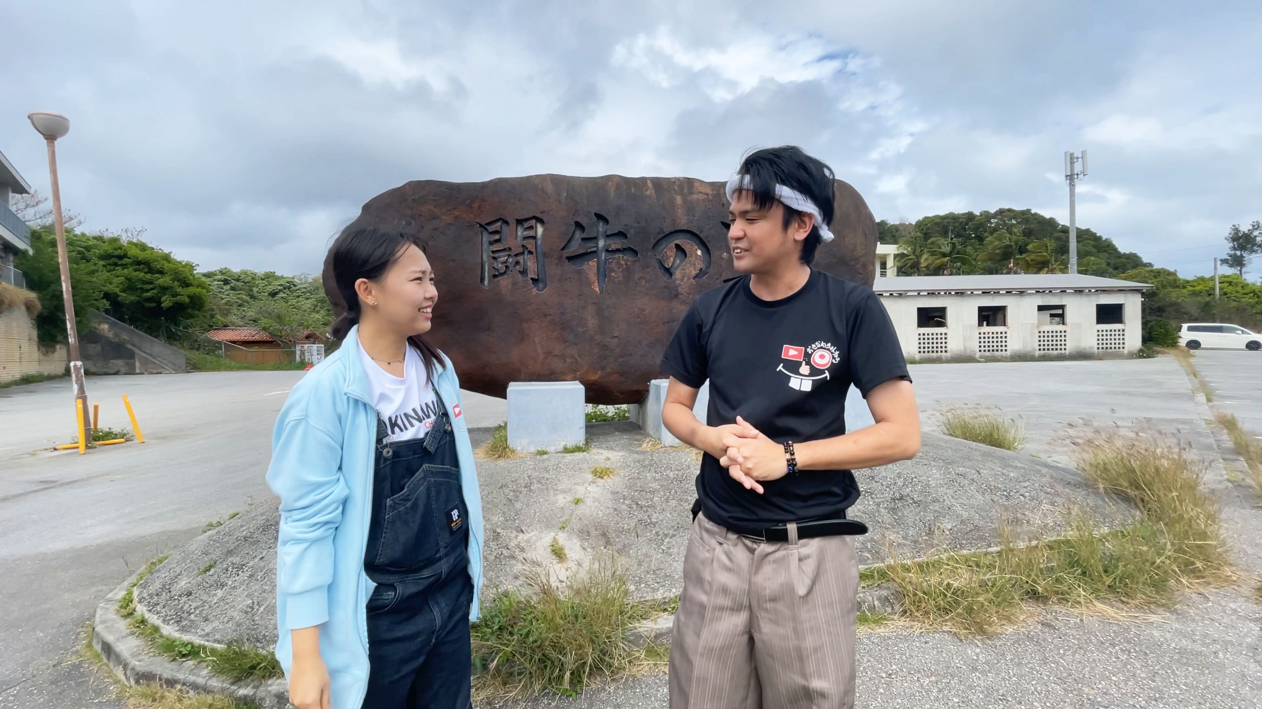 うるま市にある石川多目的ドームの前でガッツポーズをするまいこ、じゅん選手、アナウンサー伊波大志さん