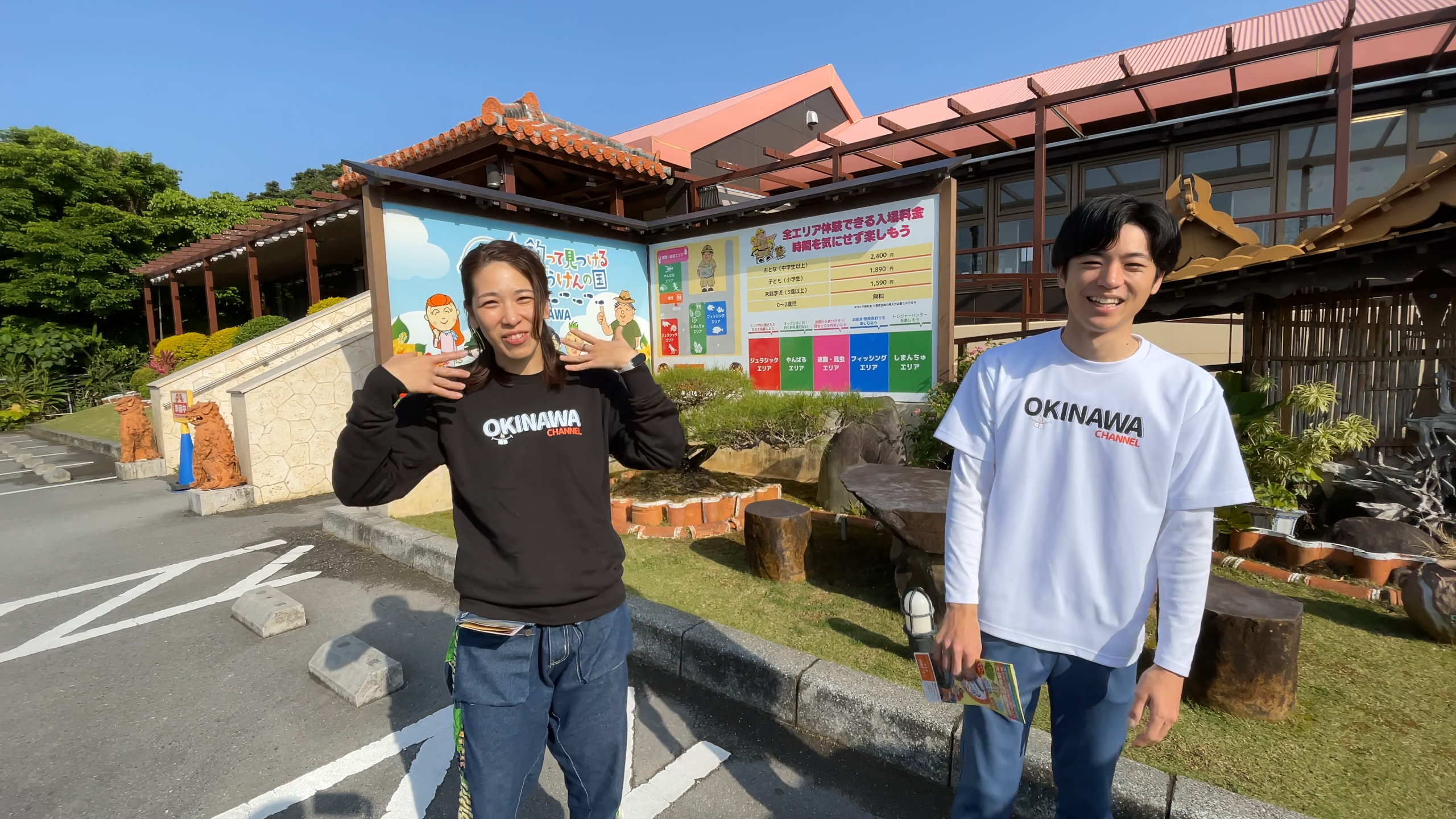 釣って見つけるぼうけんの国 沖縄の看板と青空の下でスタートするひーとーさんとあつきにいにい