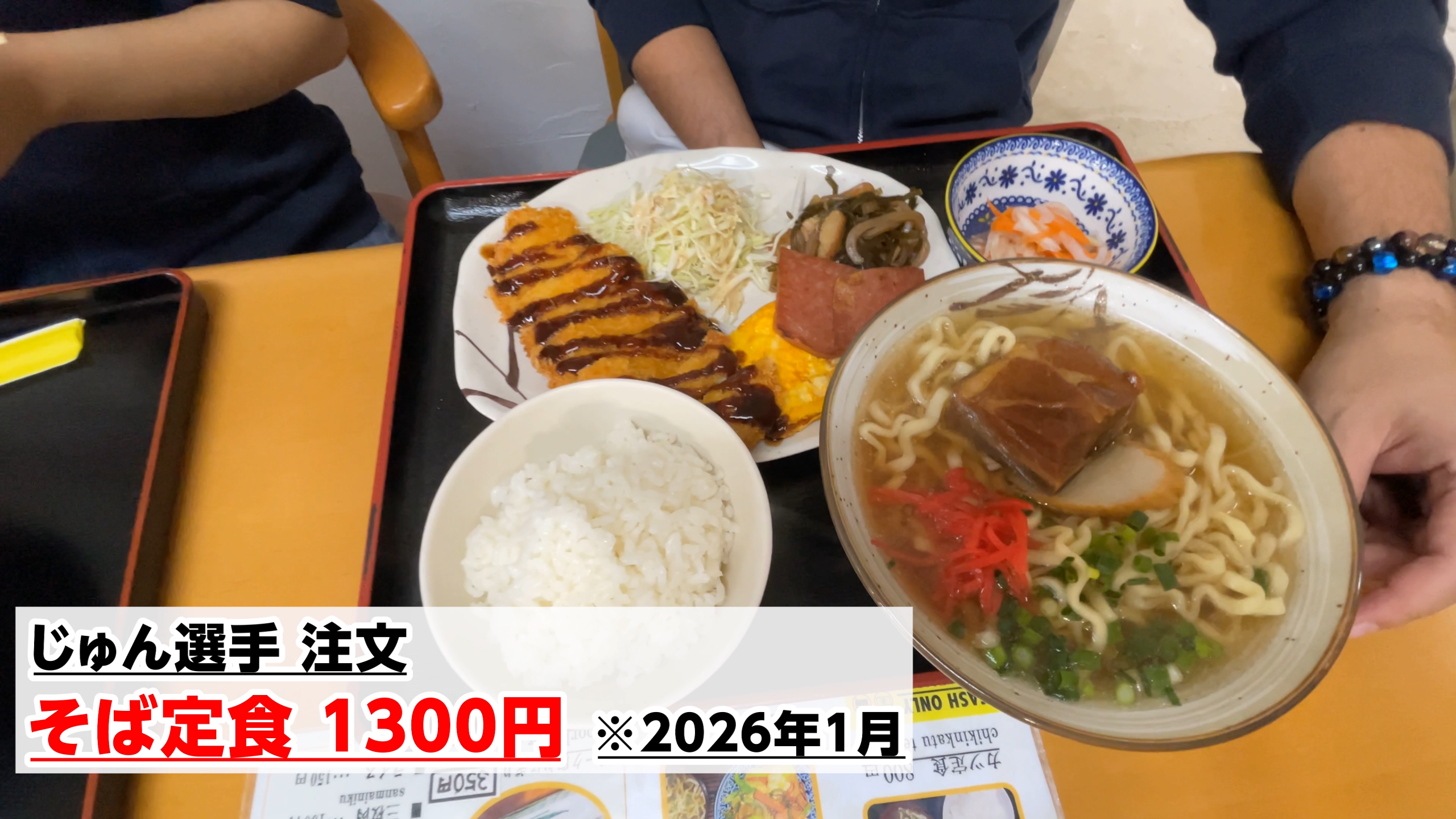 沖縄そばとトンカツなどがセットになった豪華なそば定食を堪能する様子