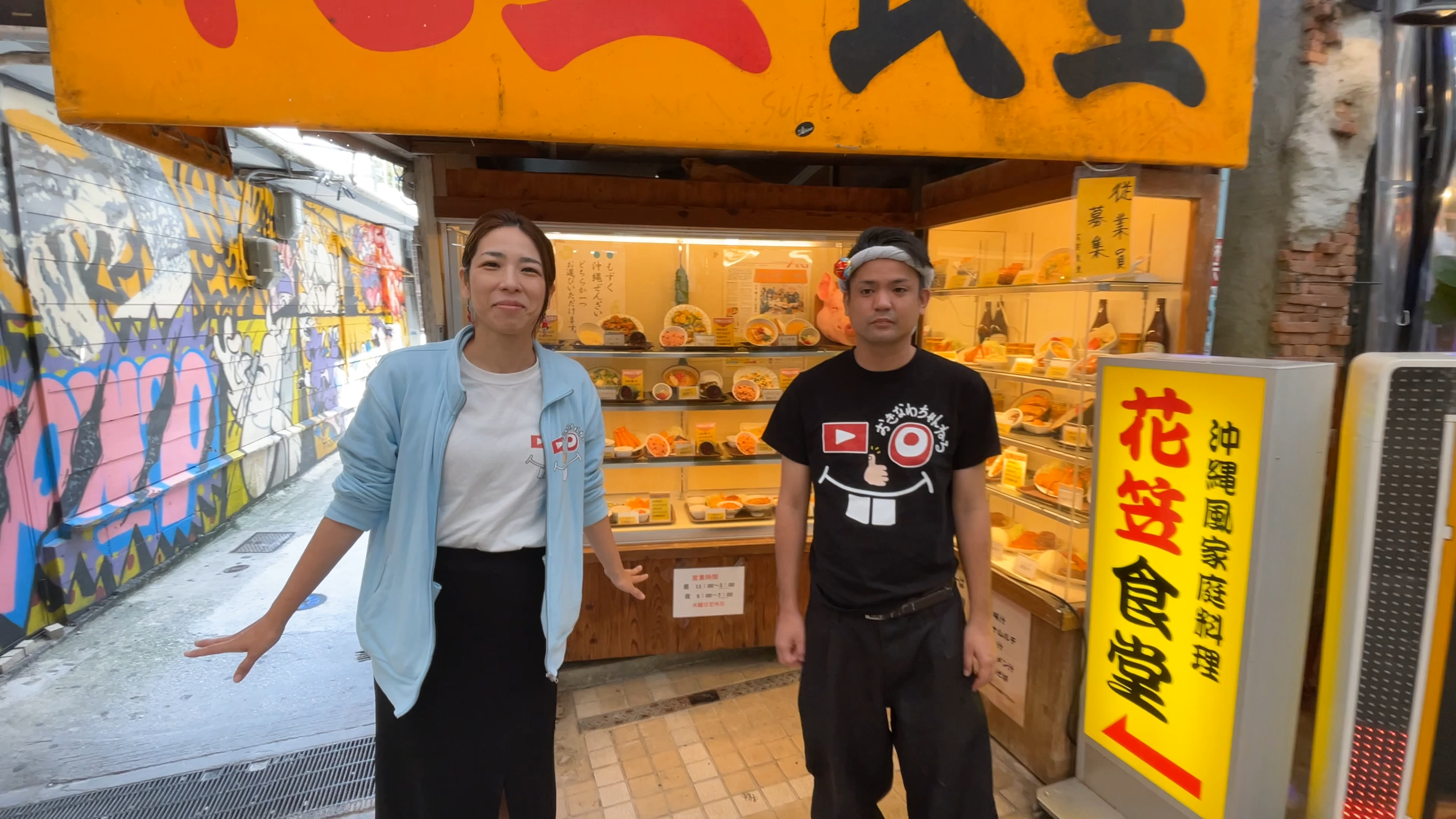 那覇市平和通りにある老舗「花笠食堂」の外観と笑顔のお二人