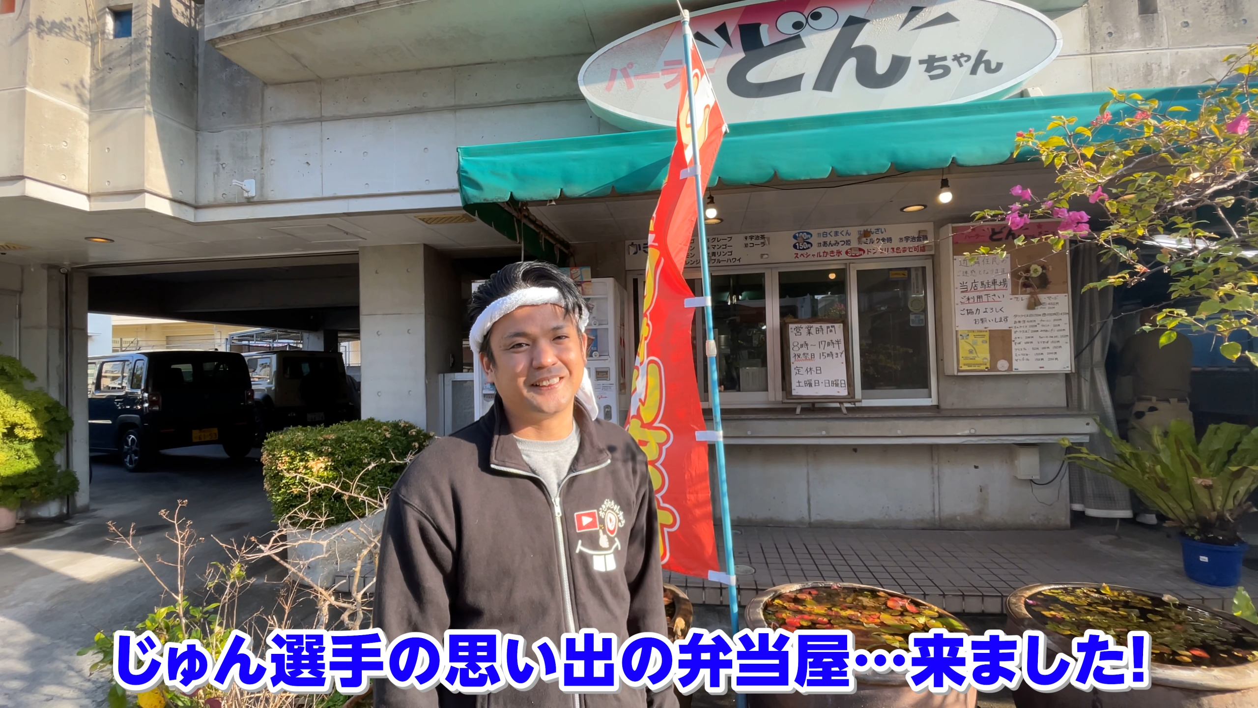 沖縄市泡瀬にある老舗「パーラーどんちゃん」の外観とレポートするじゅん選手