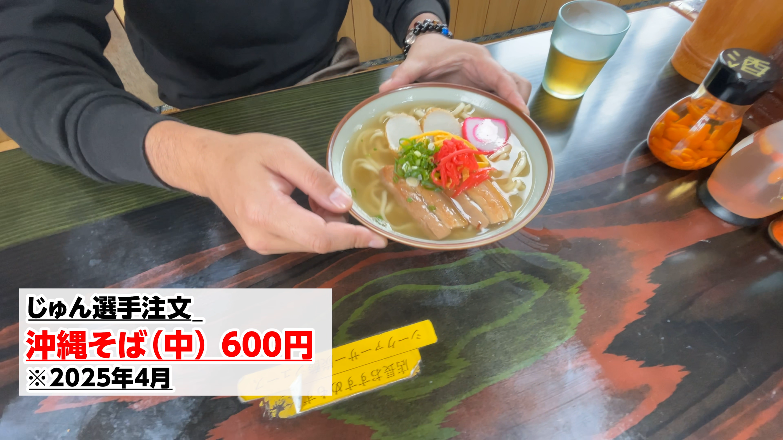 かまぼこ、紅生姜、三枚肉が綺麗に盛り付けられた色鮮やかな沖縄そば
